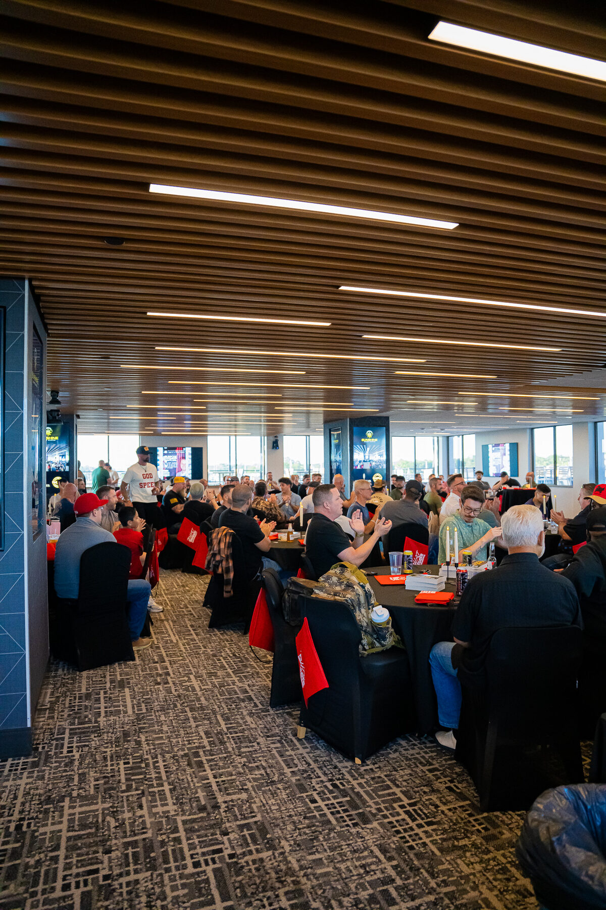 A large gathering of men seated at tables sharing a meal and fellowship at a Man Days Project community event